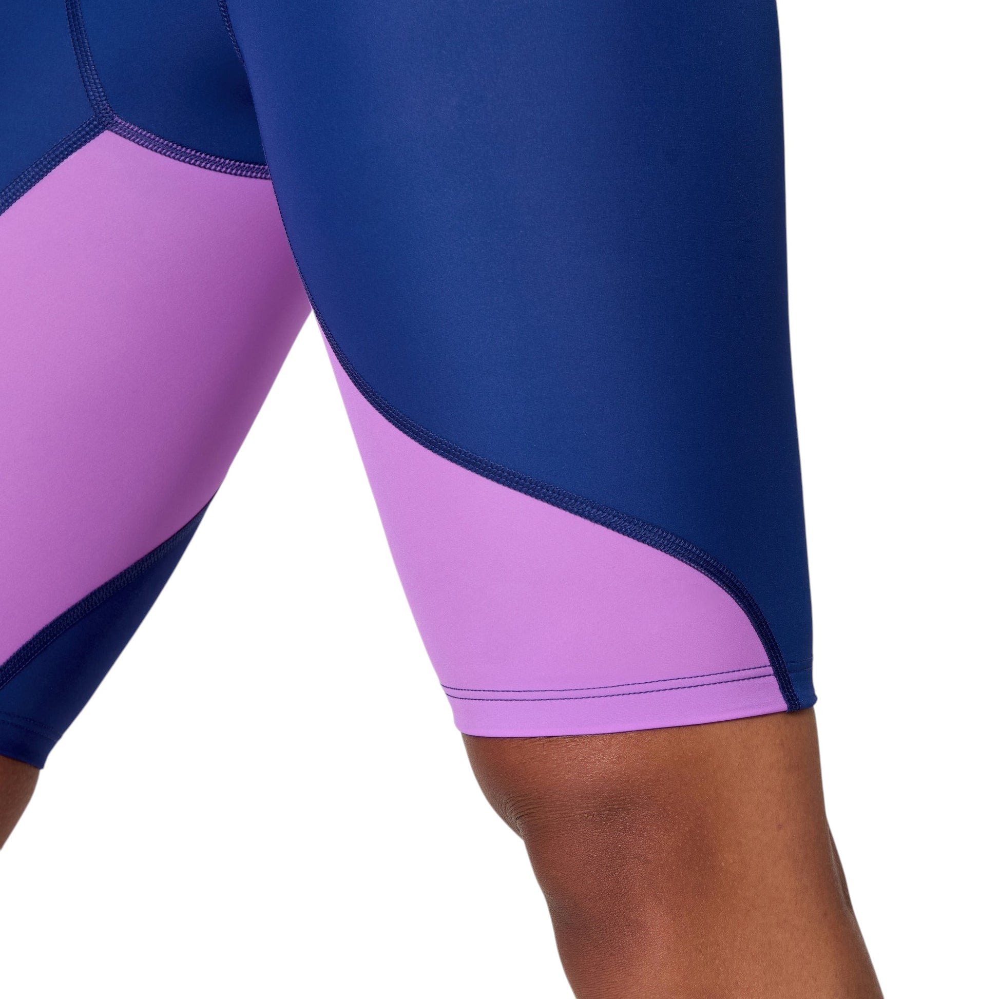 Speedo LZR Pro 2.0: Kneeskin open Back. Close-up of leg compression panels. Navy fabric meets lavender lower panels with durable stitched flat-locked seams.